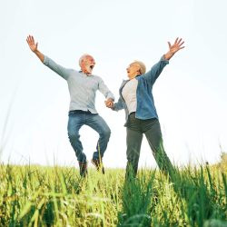 woman man outdoor senior couple happy lifestyle retirement together love jumping fun nature mature